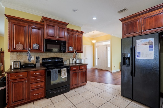 kitchen featuring crown molding, visible vents, black appliances, and dark countertops