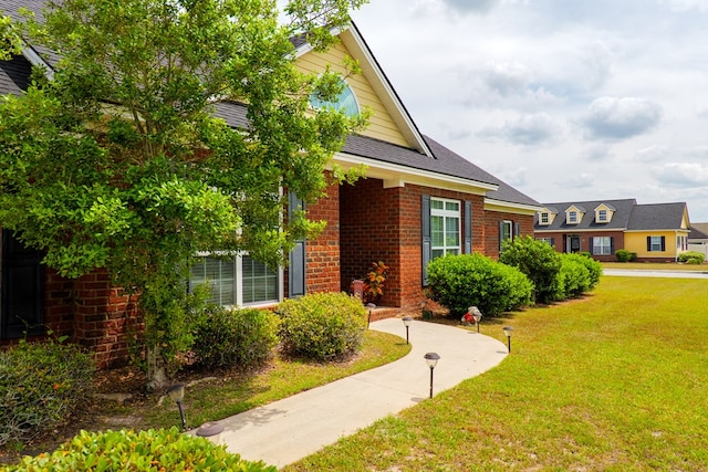 exterior space featuring a front yard and brick siding