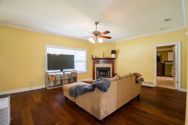 living room featuring a ceiling fan, baseboards, crown molding, a fireplace, and dark wood-style floors