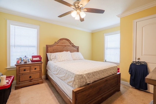 bedroom with light colored carpet, crown molding, baseboards, and a ceiling fan