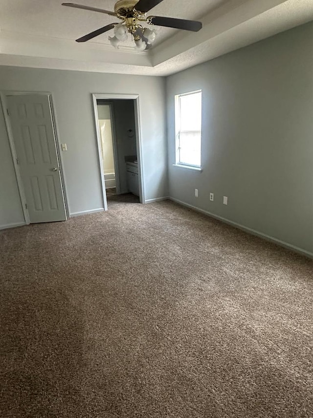 4193 Hamilton Cir, Valdosta, GA 31605 - unfurnished bedroom featuring carpet flooring, ensuite bath, ceiling fan, and a tray ceiling