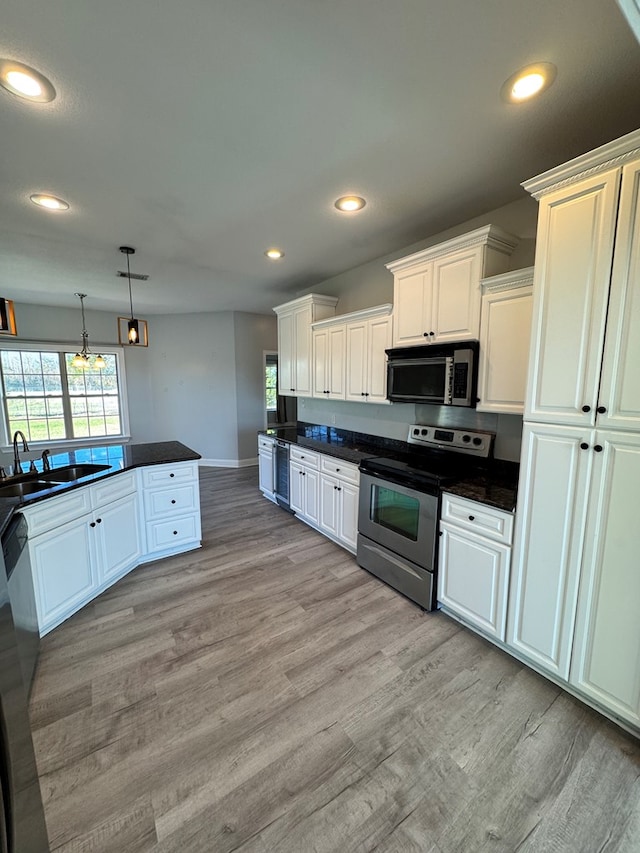 kitchen featuring sink, white cabinets, decorative light fixtures, and stainless steel range with electric stovetop