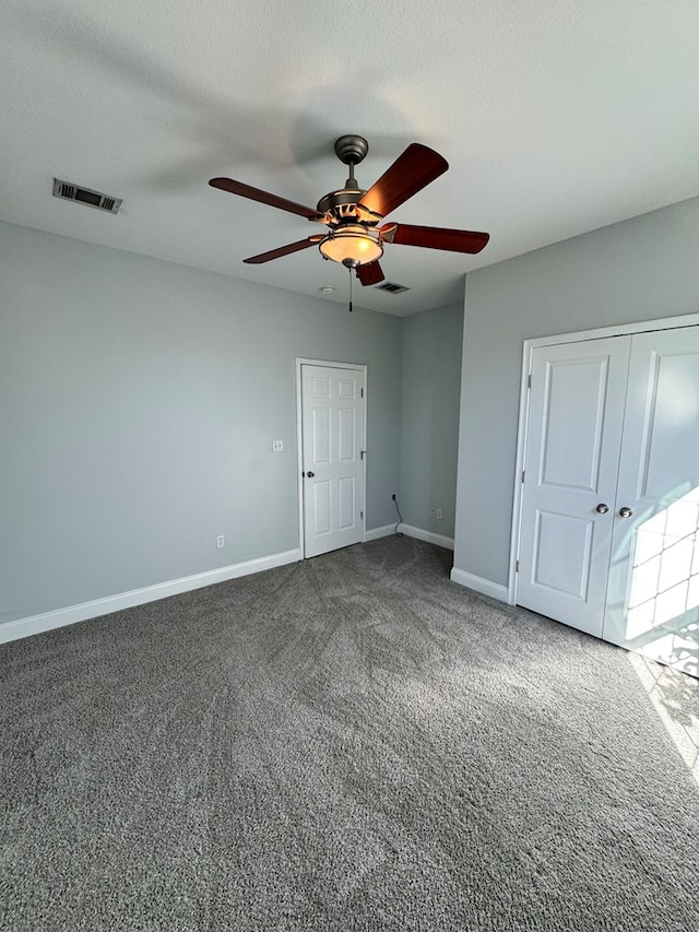 unfurnished bedroom featuring ceiling fan, a textured ceiling, and carpet flooring