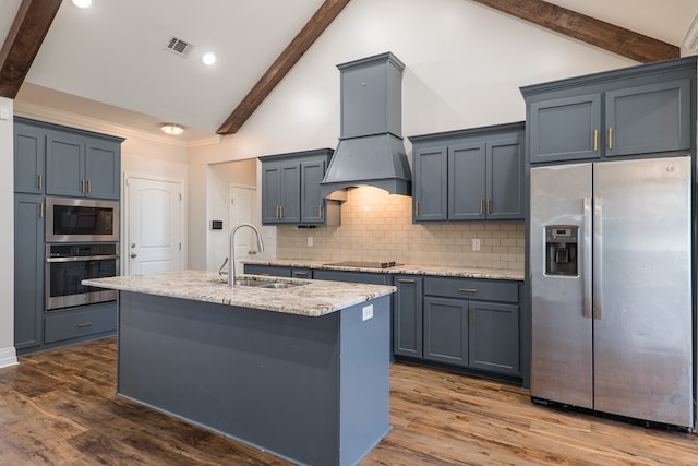 kitchen featuring dark wood-type flooring, tasteful backsplash, lofted ceiling with beams, premium range hood, and appliances with stainless steel finishes