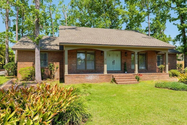 ranch-style home with a front lawn, brick siding, a porch, and roof with shingles