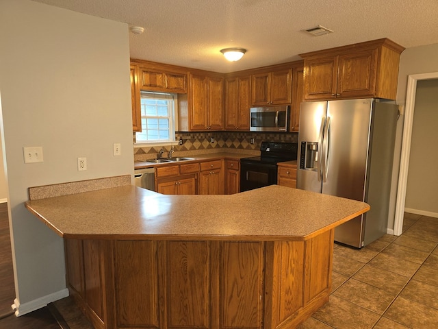 kitchen featuring sink, stainless steel appliances, tile patterned floors, kitchen peninsula, and decorative backsplash