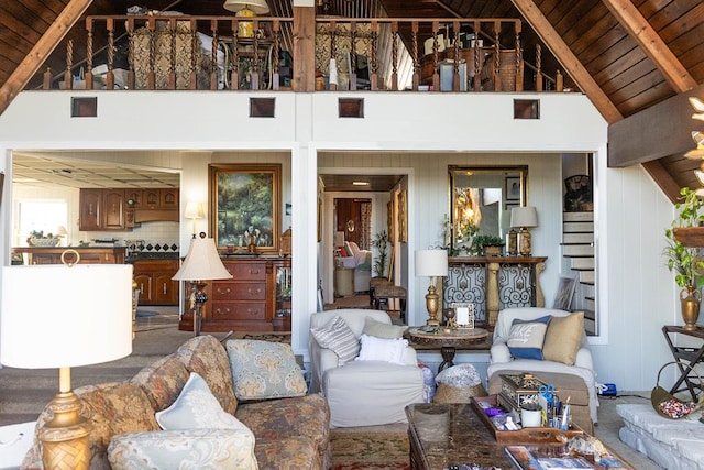 living room with beam ceiling, high vaulted ceiling, wooden ceiling, and wood walls