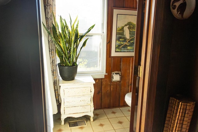 bathroom featuring wooden walls and tile patterned flooring