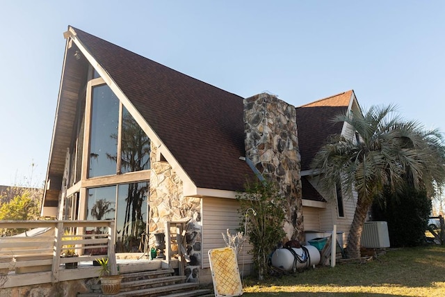 back of house featuring a lawn and a wooden deck