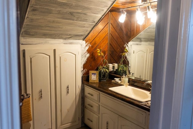 bathroom featuring vanity, wood walls, and wooden ceiling