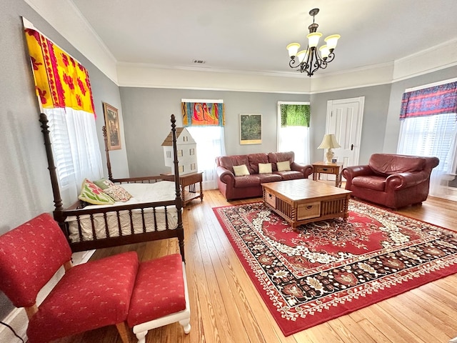 living room with wood-type flooring, a notable chandelier, and ornamental molding