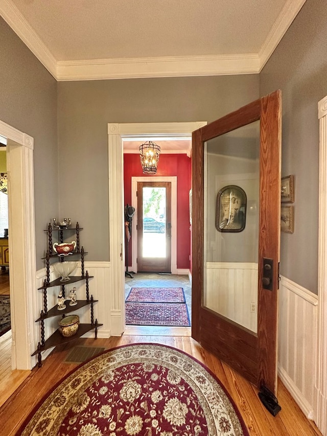 entrance foyer featuring wood-type flooring, french doors, crown molding, and a chandelier