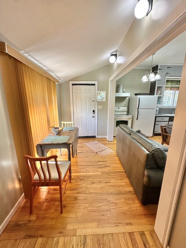 interior space featuring lofted ceiling, light hardwood / wood-style floors, and a notable chandelier