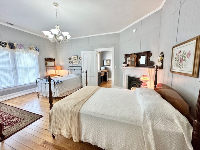 bedroom with a notable chandelier, ornamental molding, and hardwood / wood-style floors