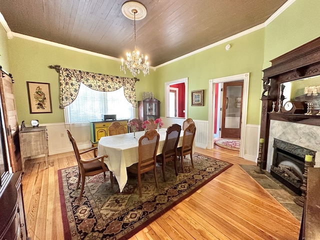 dining area featuring wood-type flooring, crown molding, a chandelier, and wooden ceiling