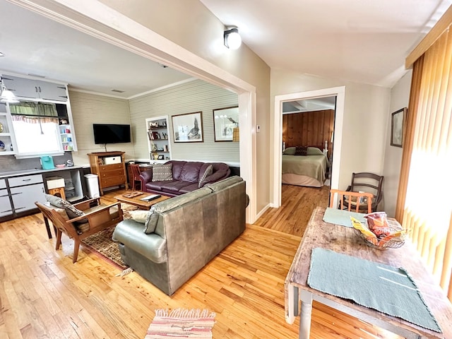 living room featuring crown molding and light wood-type flooring