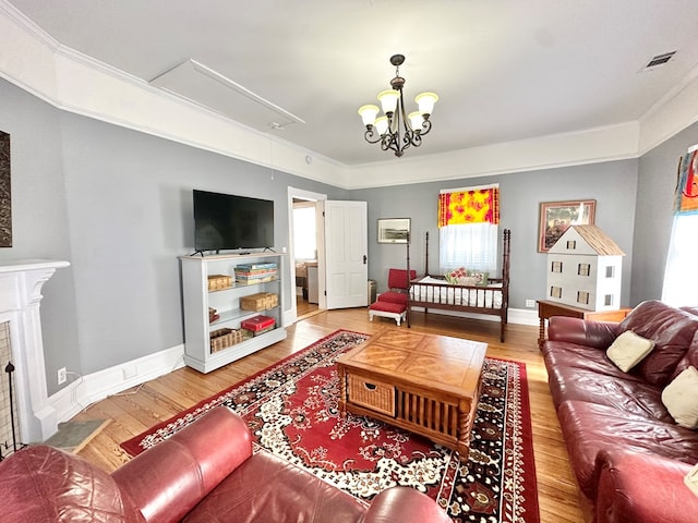 living room featuring wood-type flooring, a notable chandelier, and ornamental molding