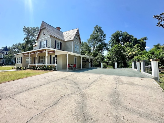 view of home's exterior with covered porch and a lawn