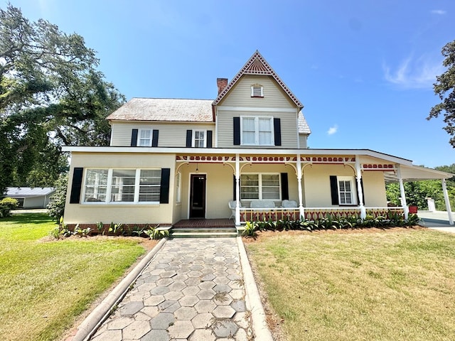 victorian house with a front yard and a porch