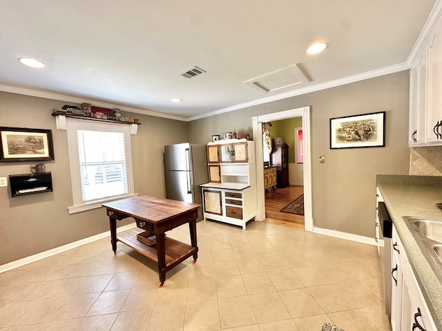 kitchen featuring light tile patterned floors, decorative backsplash, crown molding, and white cabinetry