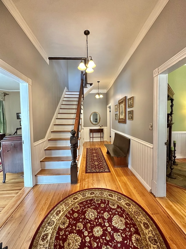 interior space with hardwood / wood-style flooring, ornamental molding, and an inviting chandelier