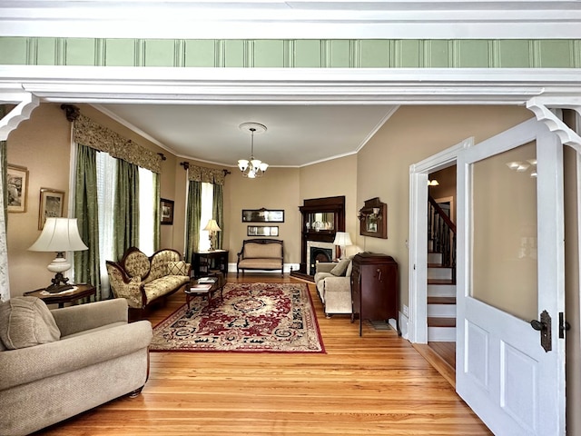 living room with an inviting chandelier, crown molding, and hardwood / wood-style floors