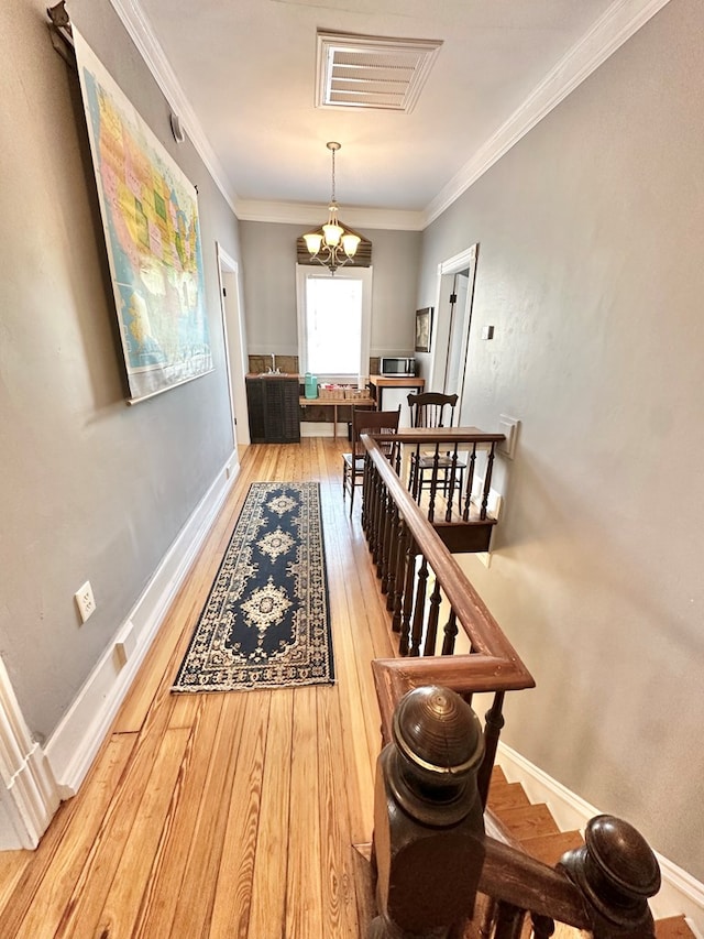 dining space featuring an inviting chandelier, crown molding, and hardwood / wood-style flooring