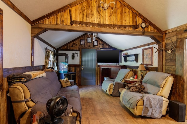 living room with vaulted ceiling with beams, light wood-type flooring, ceiling fan, and wood walls