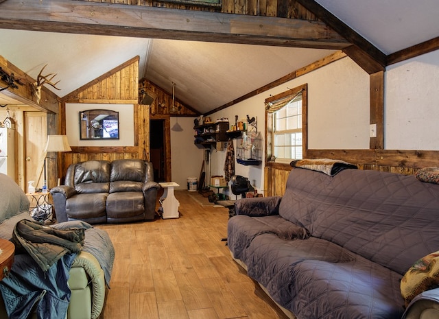 living room with lofted ceiling with beams, wood walls, and light hardwood / wood-style floors