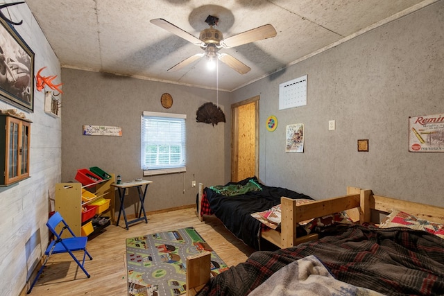 bedroom with hardwood / wood-style flooring, ceiling fan, and ornamental molding