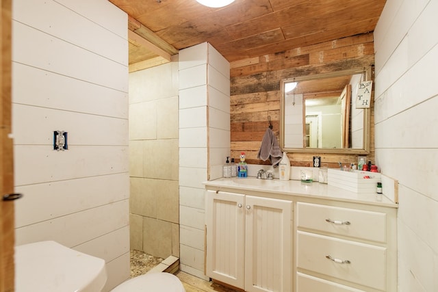 bathroom featuring wooden walls, vanity, wooden ceiling, and toilet