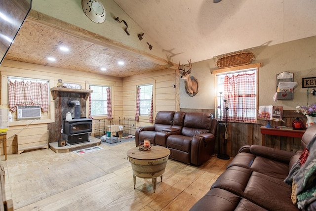 living room featuring wood-type flooring, vaulted ceiling, a wood stove, and cooling unit