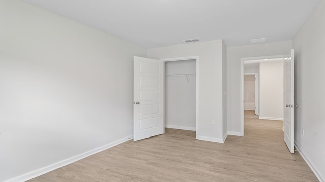 unfurnished bedroom featuring a closet and light wood-type flooring