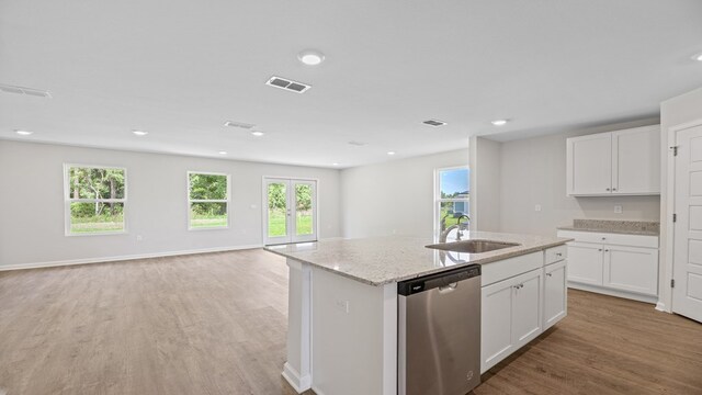 kitchen featuring sink, white cabinetry, dishwasher, and a center island with sink