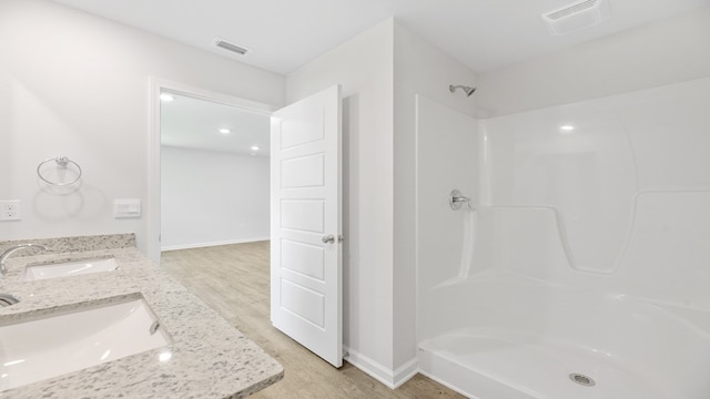 bathroom featuring vanity, a shower, and hardwood / wood-style flooring