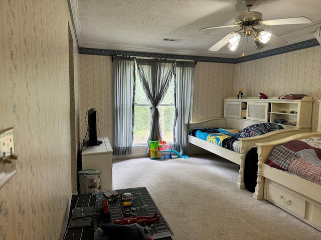 bedroom featuring a textured ceiling, ceiling fan, carpet floors, and crown molding