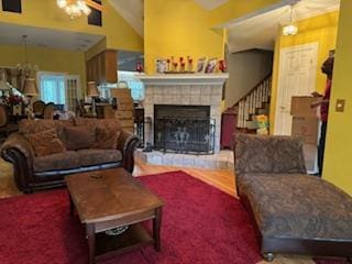 carpeted living room with a fireplace, vaulted ceiling, and ceiling fan