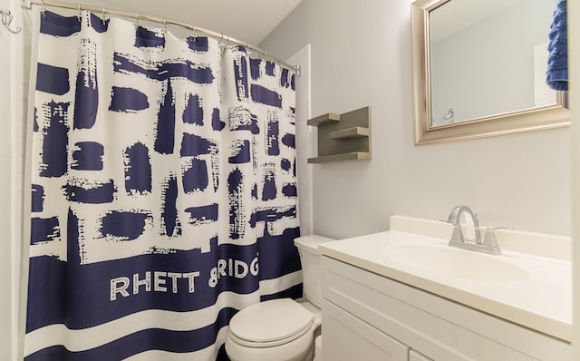 bathroom with toilet, walk in shower, and vanity