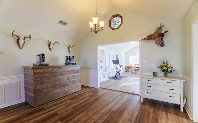 interior space featuring vaulted ceiling, dark wood-type flooring, and an inviting chandelier