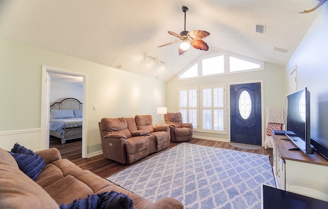 living room with ceiling fan, dark hardwood / wood-style flooring, a textured ceiling, and lofted ceiling