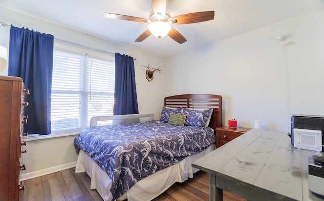 bedroom featuring ceiling fan, multiple windows, and hardwood / wood-style floors