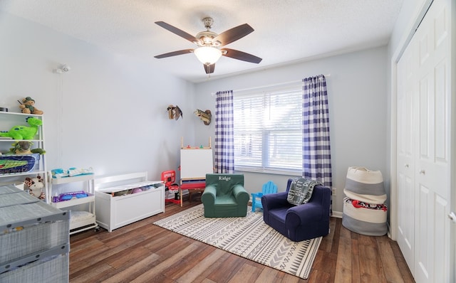 interior space with a textured ceiling, dark wood-type flooring, and ceiling fan