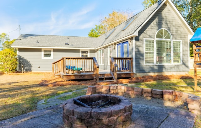 back of house featuring an outdoor fire pit, a deck, and a patio