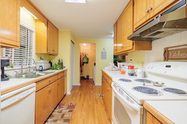 kitchen with white appliances, light hardwood / wood-style flooring, tasteful backsplash, ornamental molding, and sink