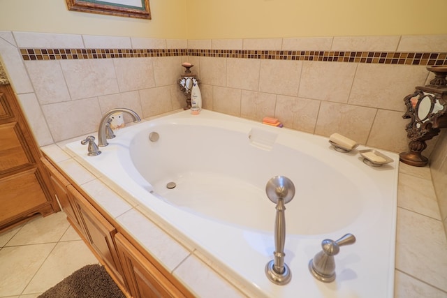 bathroom with a relaxing tiled tub and tile patterned floors