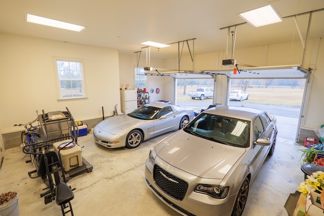 garage featuring white refrigerator and a garage door opener