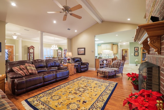 living room featuring crown molding, vaulted ceiling with beams, a brick fireplace, hardwood / wood-style flooring, and ceiling fan with notable chandelier