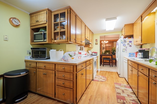 kitchen featuring white appliances, a notable chandelier, sink, and light hardwood / wood-style floors