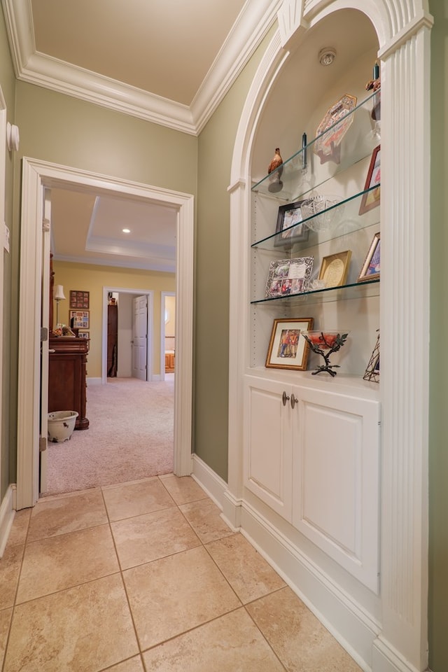 corridor with crown molding and light carpet