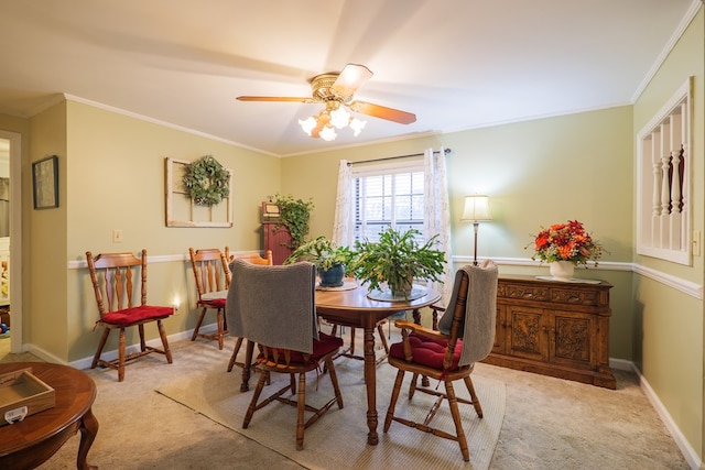 dining space featuring light carpet, ceiling fan, and crown molding